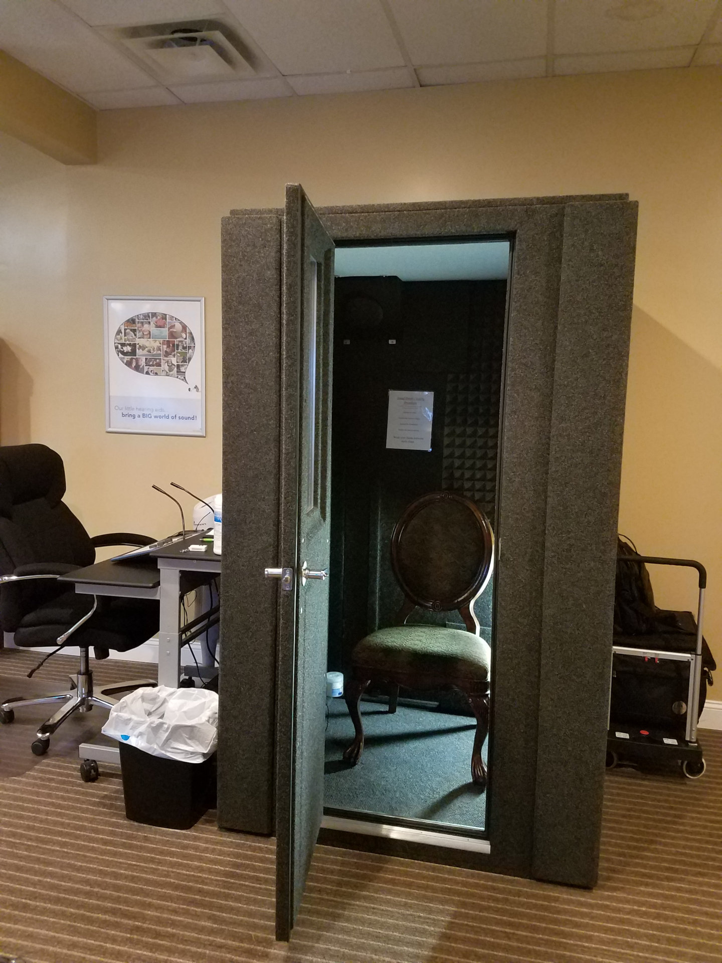 audio booth with chair inside and testing equipment outside