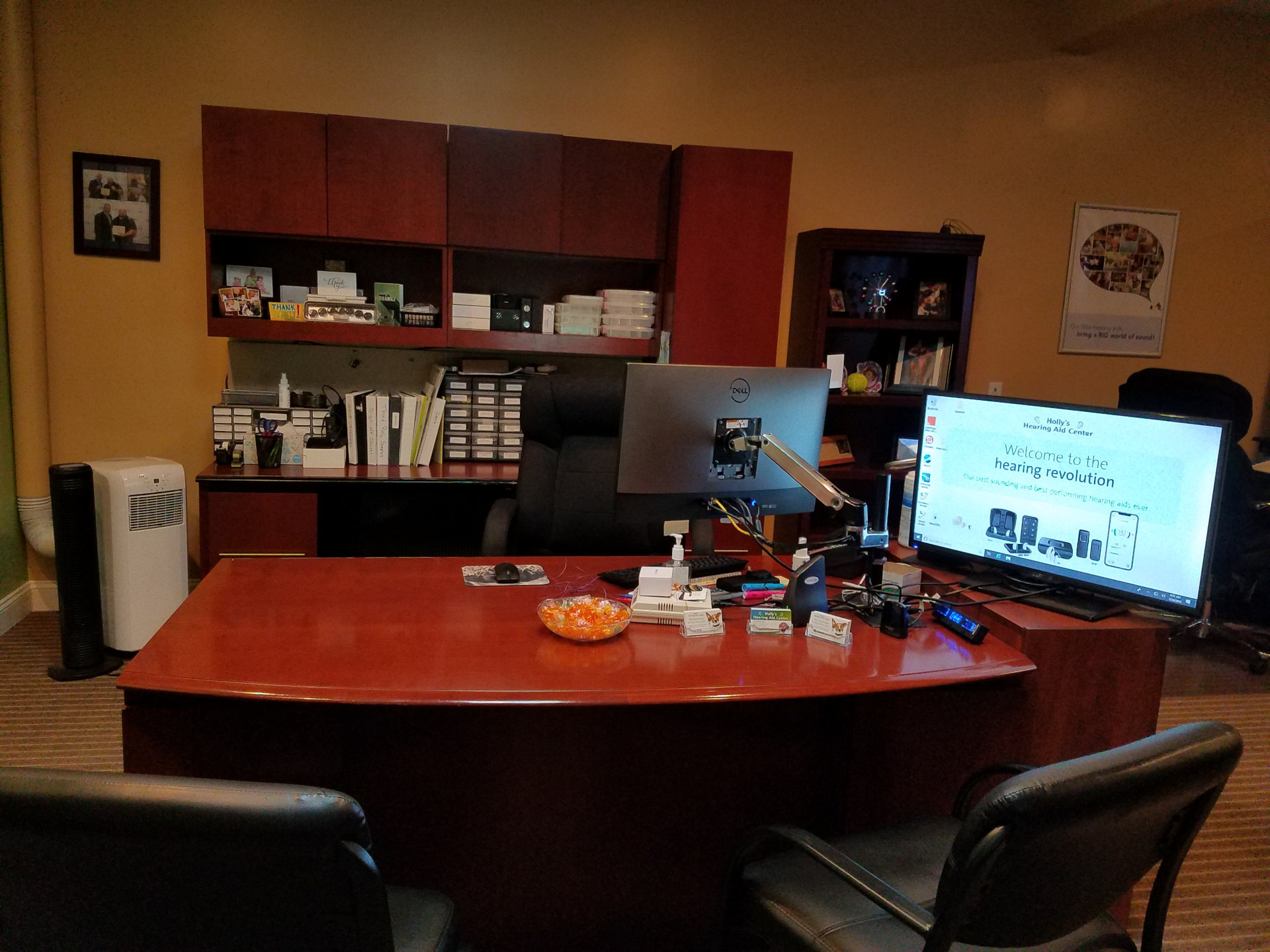 office with cabinets on back wall and desk with chairs and monitors