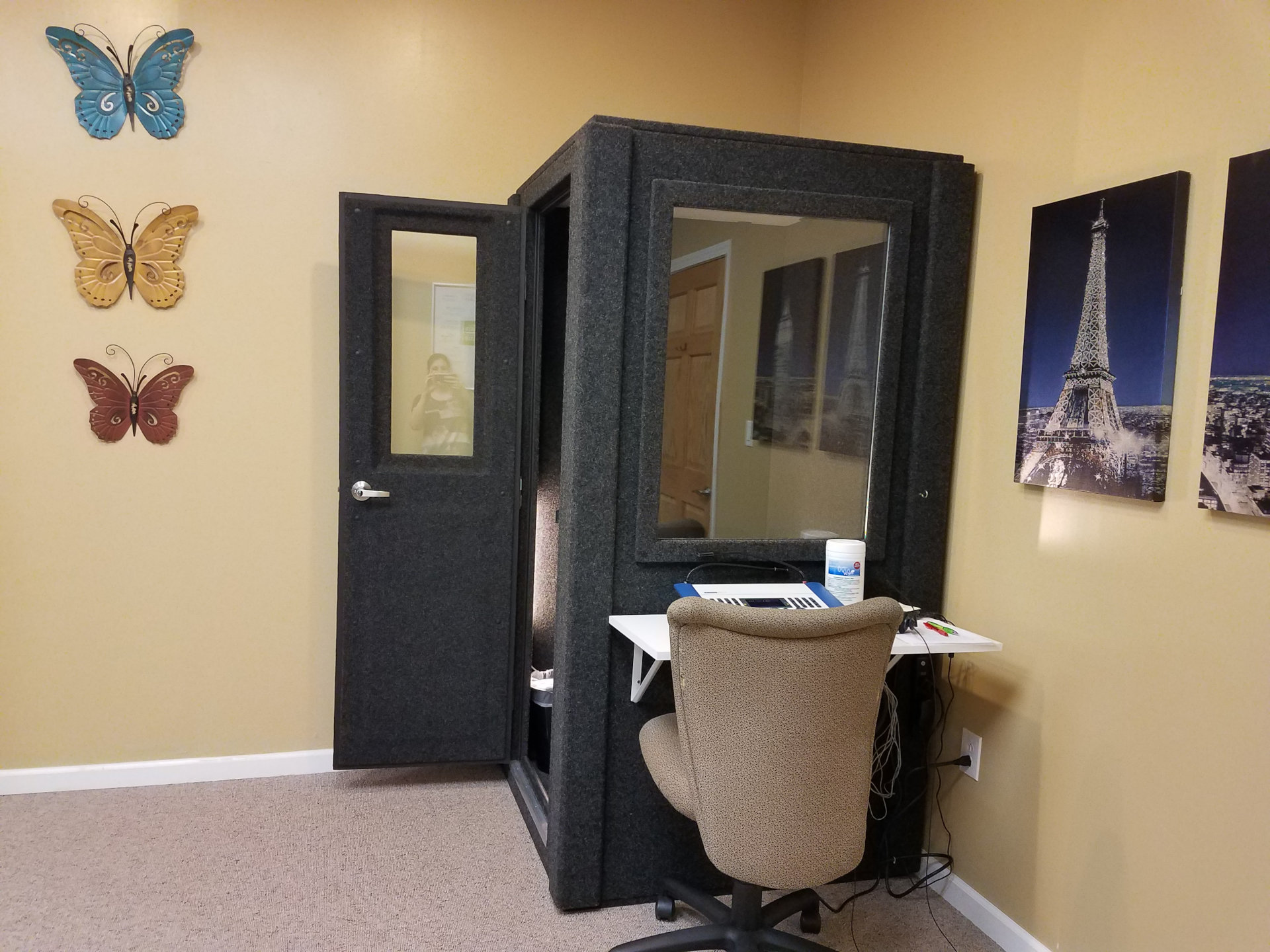 audio booth in corner with testing equipment and decorative images on walls