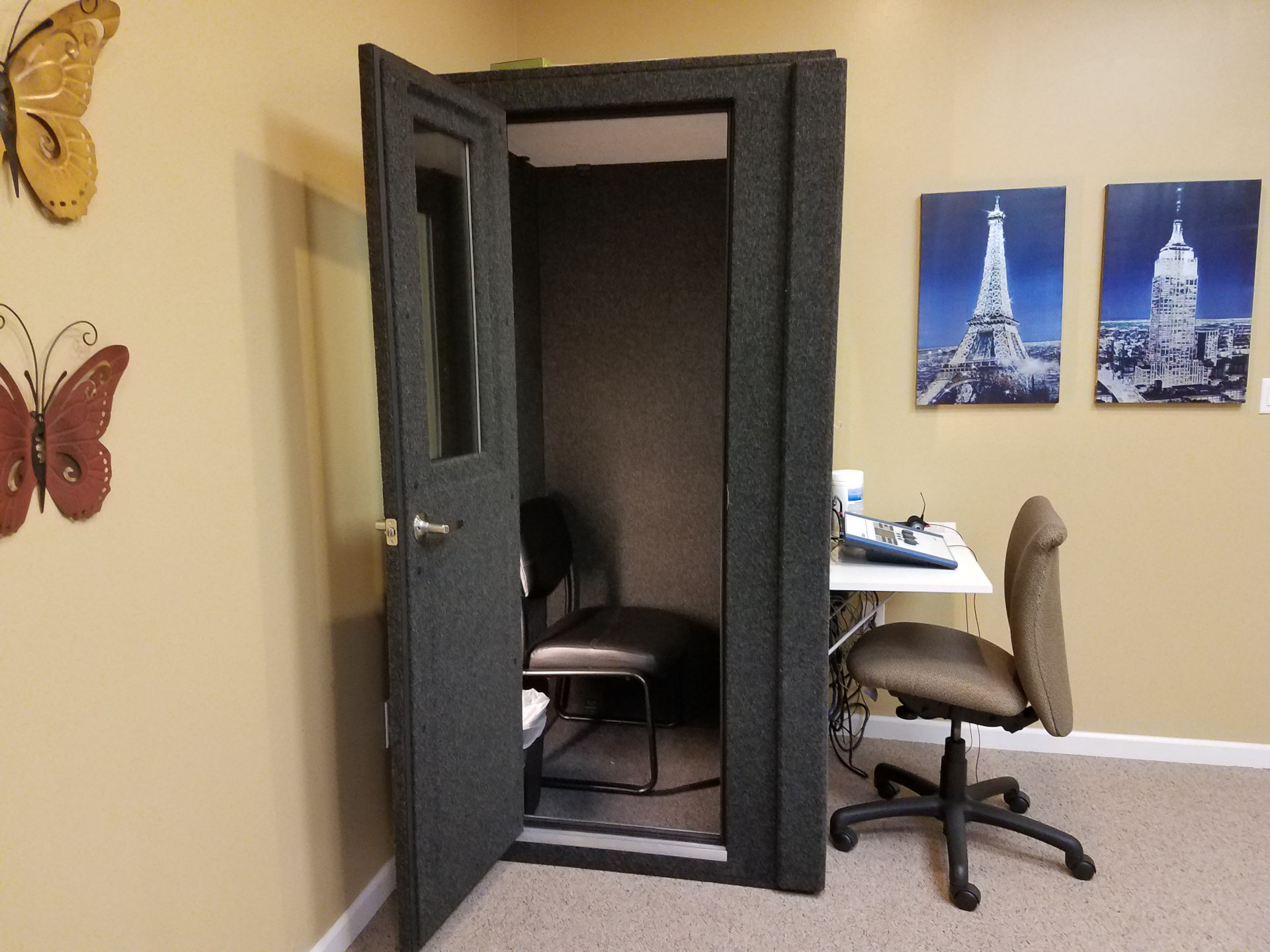 audio booth in corner with testing equipment and decorative images on walls
