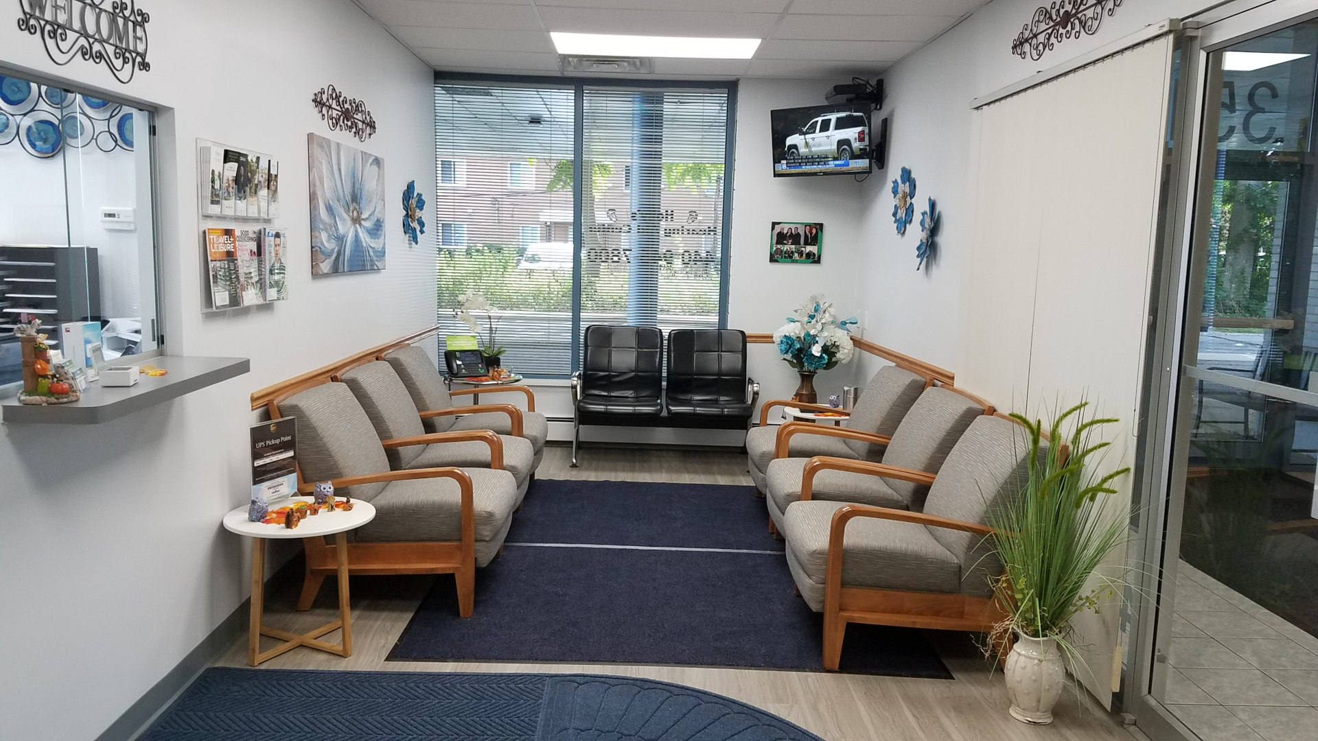 front lobby waiting area with chairs lining the walls and tv mounted near ceiling on back wall