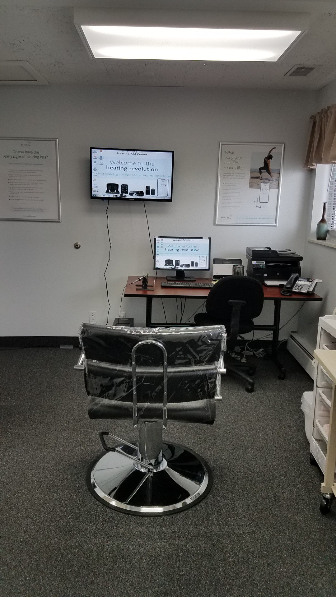 chair in wax removal room with desk and monitors on back wall